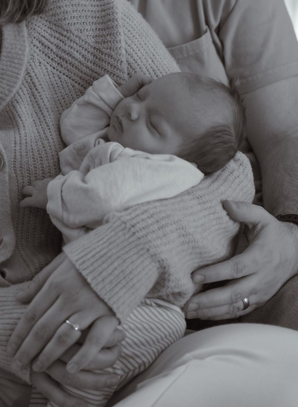 In-home newborn session with baby swaddled and peacefully resting in parent’s arms in Tri-Cities WA