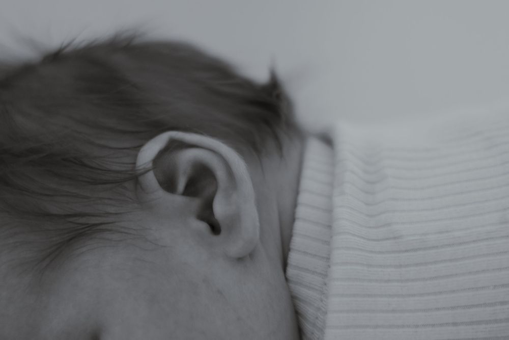 Black and white close-up of newborn snuggled into parent's chest during in-home session in Eastern Washington