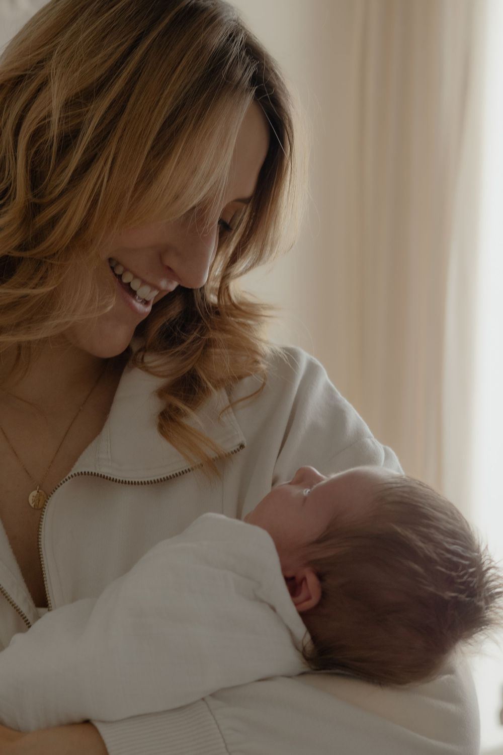 New mom cradling her newborn during an in-home lifestyle session in Kennewick WA