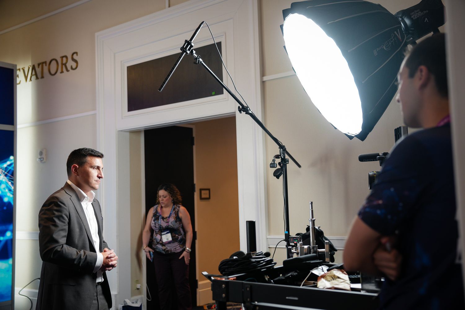 Behind the scenes photo of a video production shoot with lighting setup and camera equipment in a hallway at the Gaylord National Resort