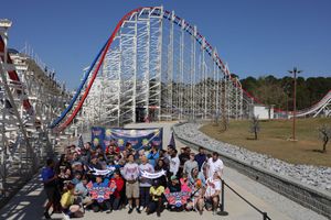 Racing riders speed down the steep track of Texas Giant roller coaster at Six Flags Over Texas theme park.