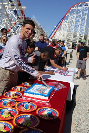 Red table with championship belts displayed at a Six Flags amusement park promotional event.