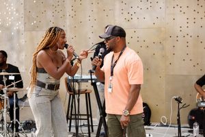Two performers singing together on stage during a live performance.