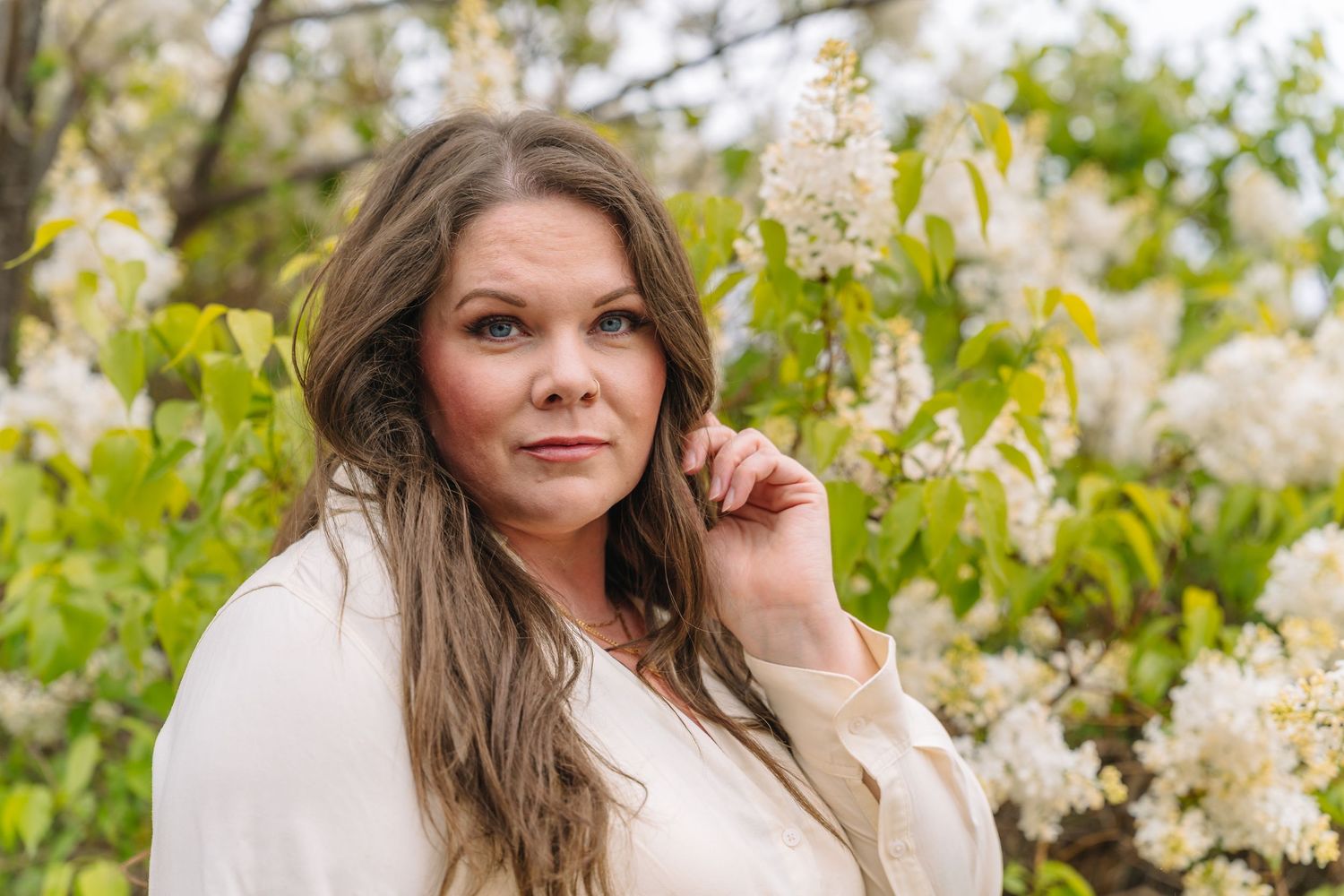 Portrait of a person among blooming white flowers on a spring day.