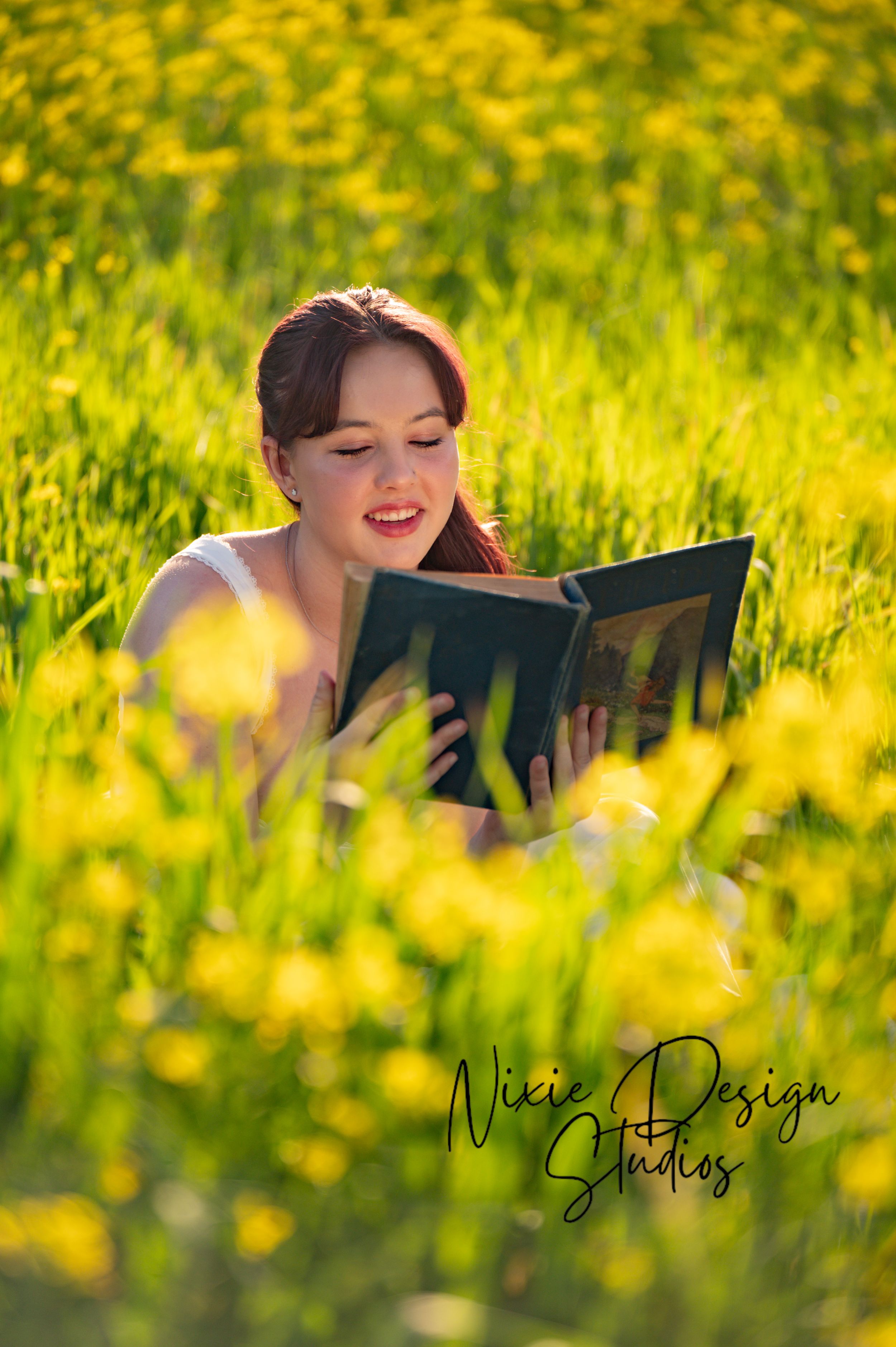 A person reading a book while laying in a field of vibrant yellow wildflowers on a sunny spring day.