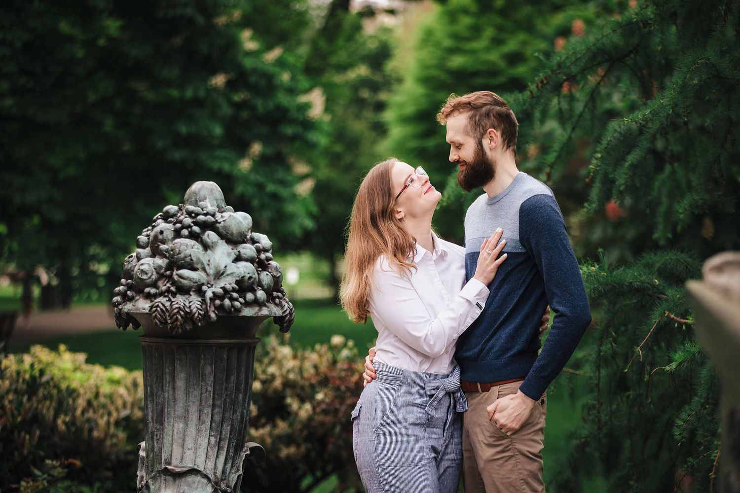 Romantic formal portrait of engaged couple standing by ornate bronze fountain at George Robert White Memorial in Boston Public Garden