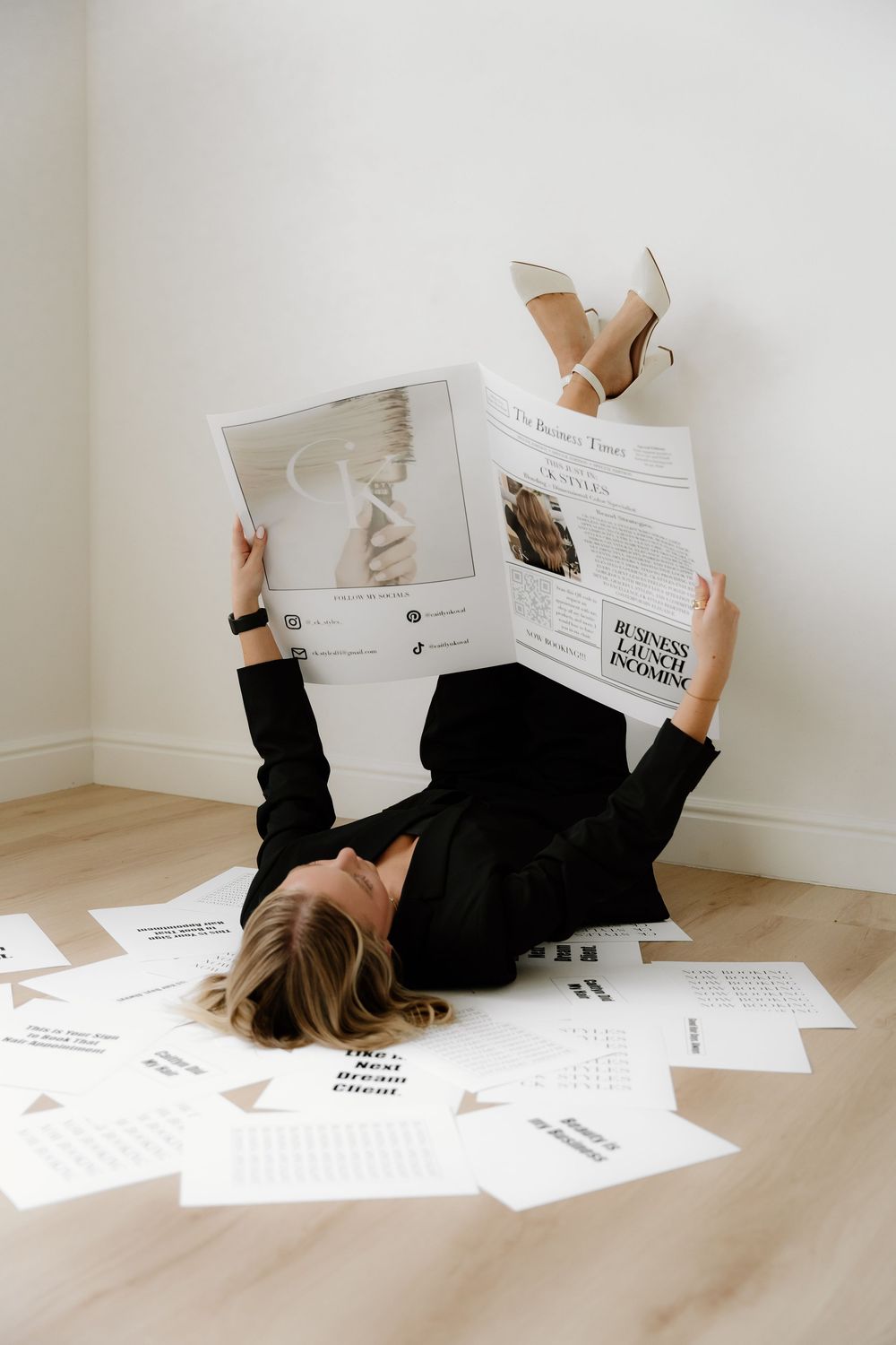 Creative business photo with magazines and papers scattered on wooden floor.