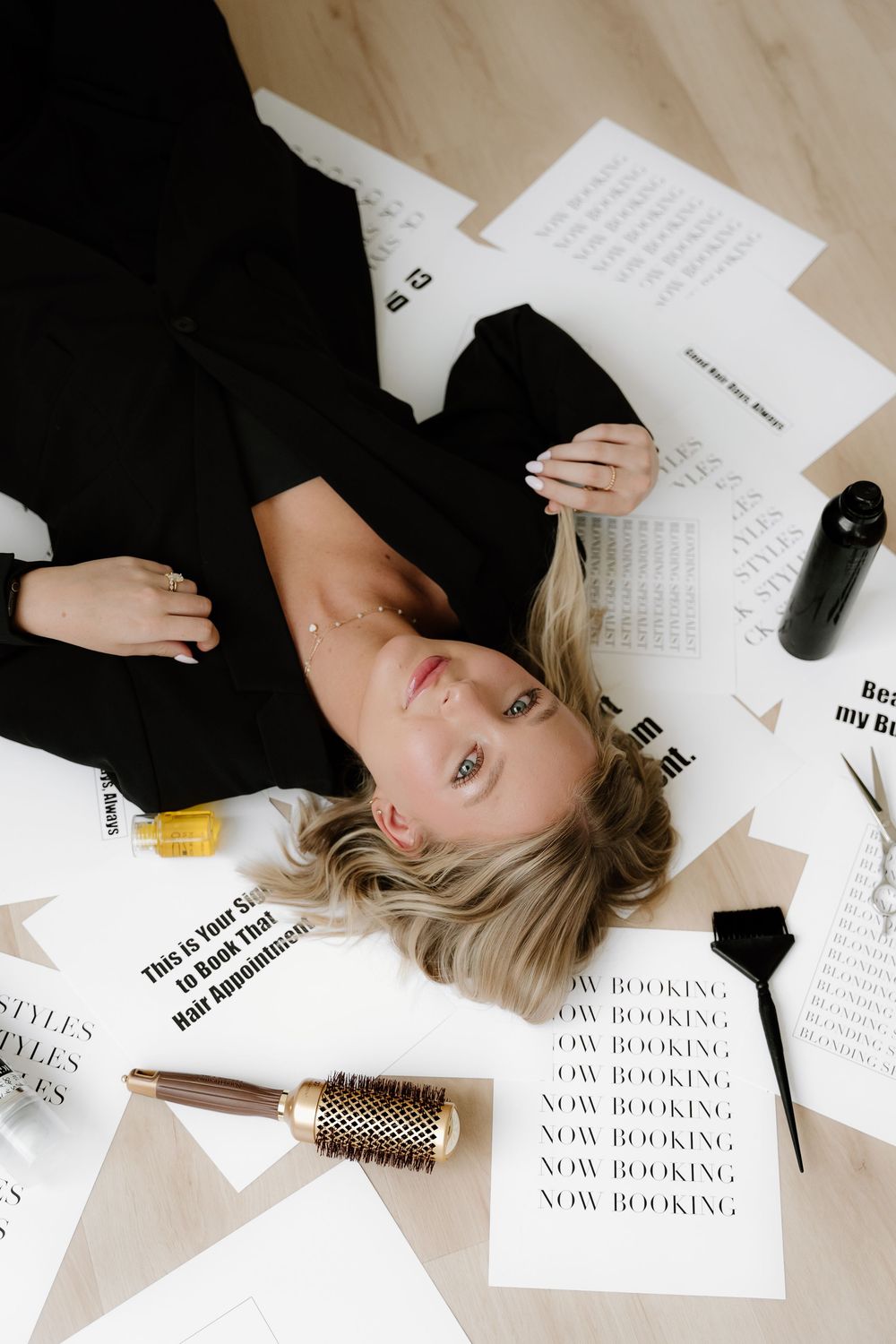 Artistic flatlay with scattered papers, hair brush and stationery items on light background.