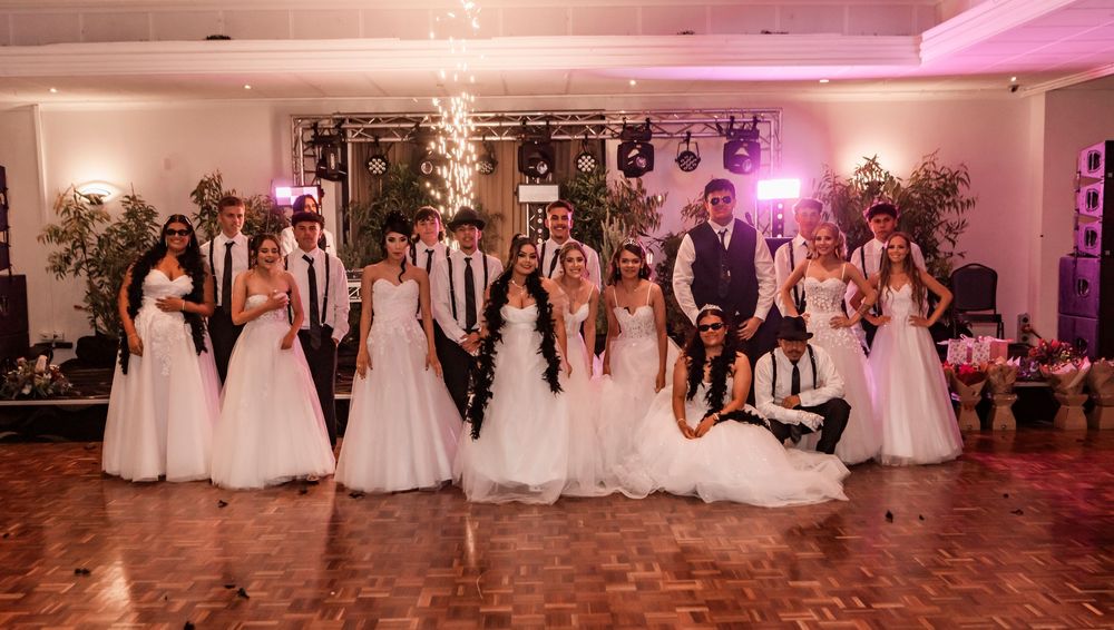 A panoramic sequence of scenes from a wedding reception showing people dancing and celebrating in a pink-lit ballroom.