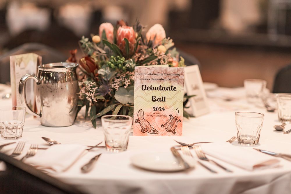 Elegant table setting at wedding reception with pink floral centerpiece and vintage style table number card.