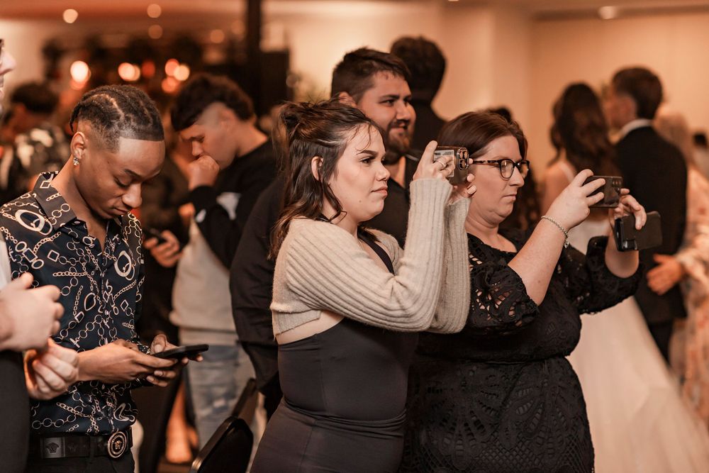 Couples dancing at an elegant formal event with warm lighting and festive atmosphere.