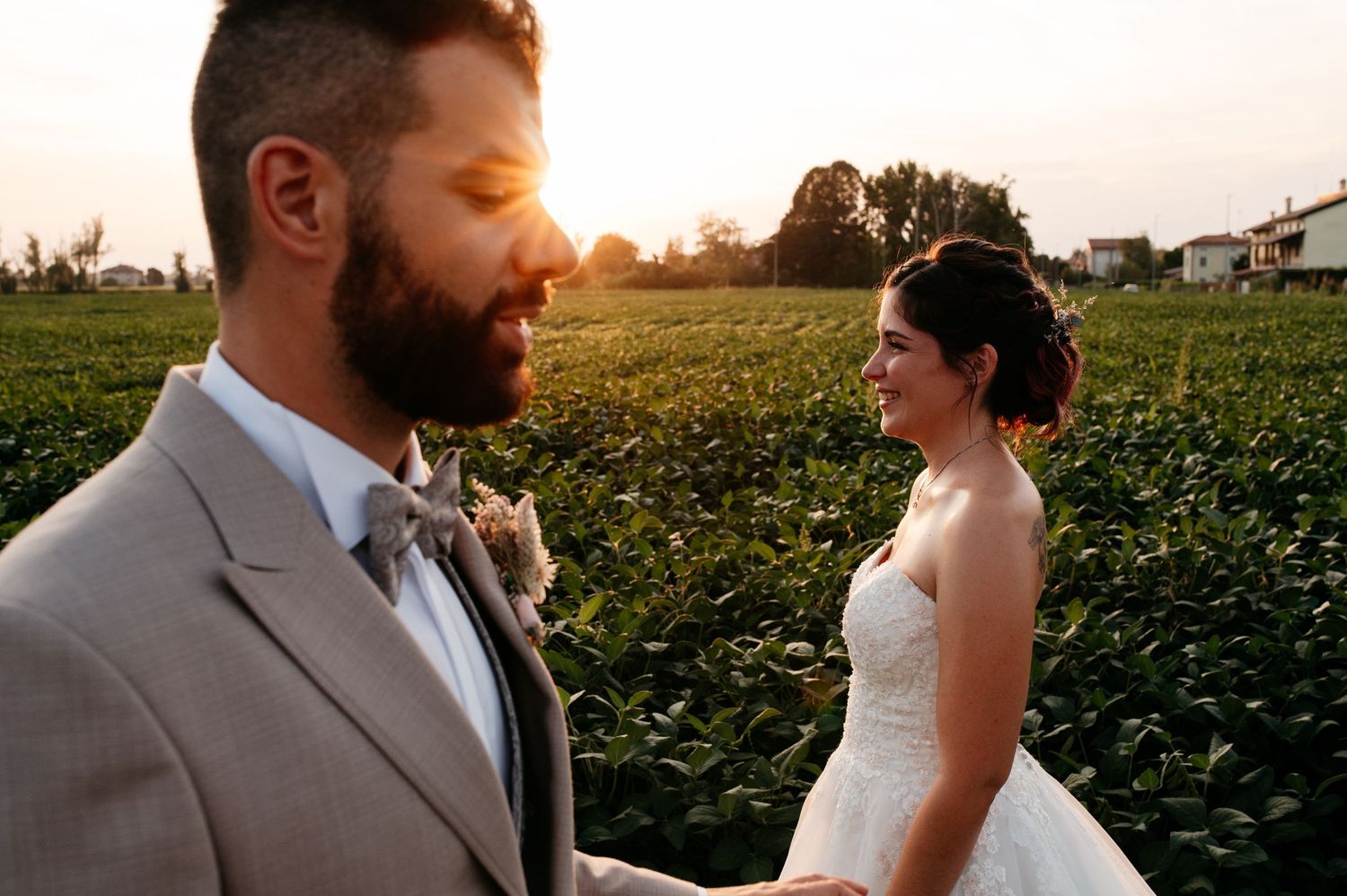 Happy couple shares romantic moment in garden setting with glowing autumn colors and white flowers.
