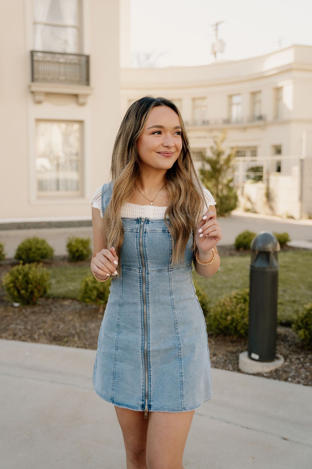 A light blue denim dress outfit photographed outdoors with classic architecture in background.