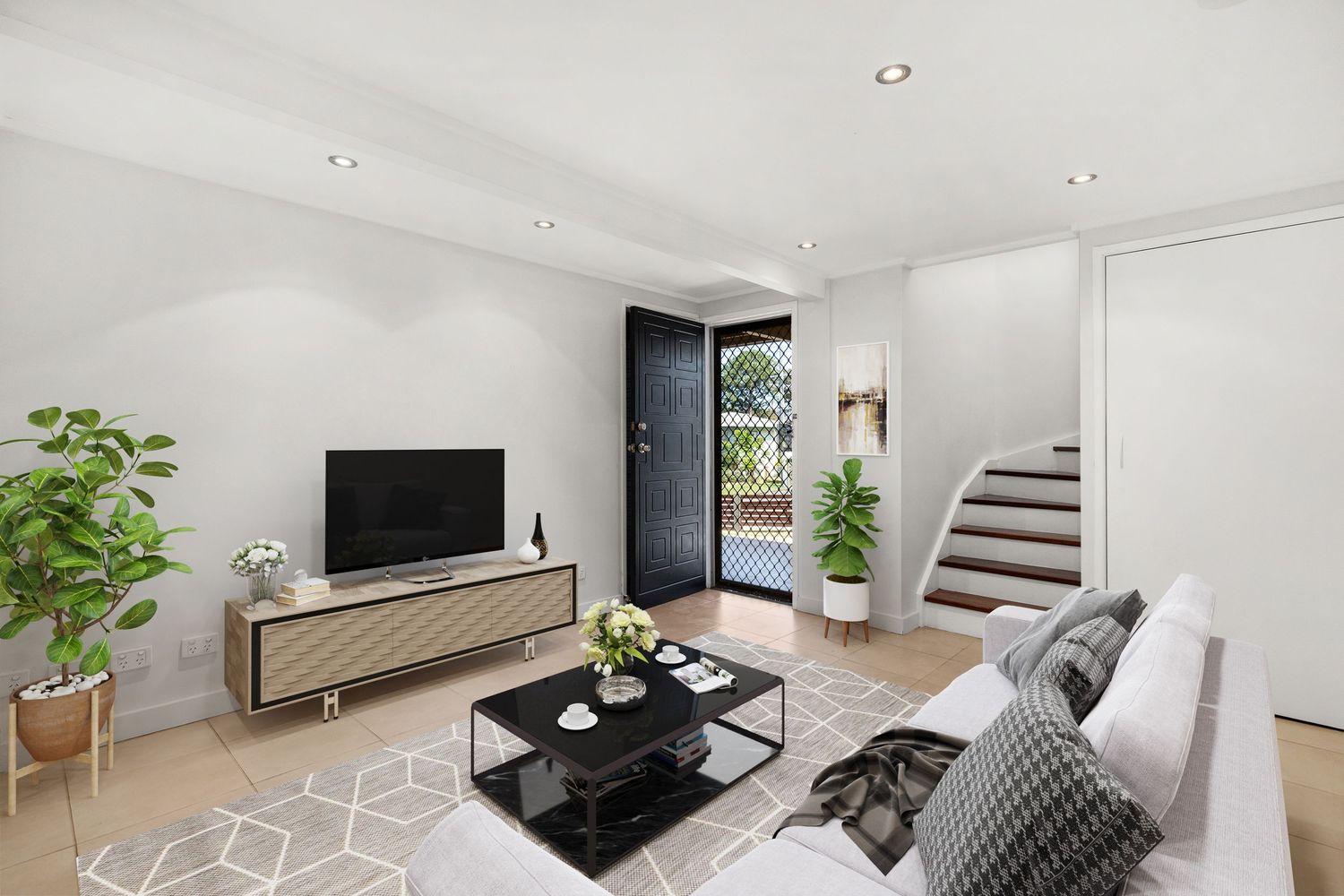 Contemporary living room with geometric-patterned floor, grey sofa, TV unit, and staircase leading to upper level.