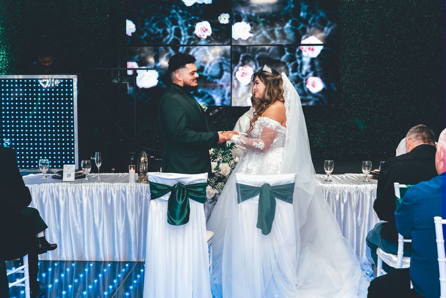 Elegant wedding reception venue with white tables and crystal chandeliers creating a romantic atmosphere.
