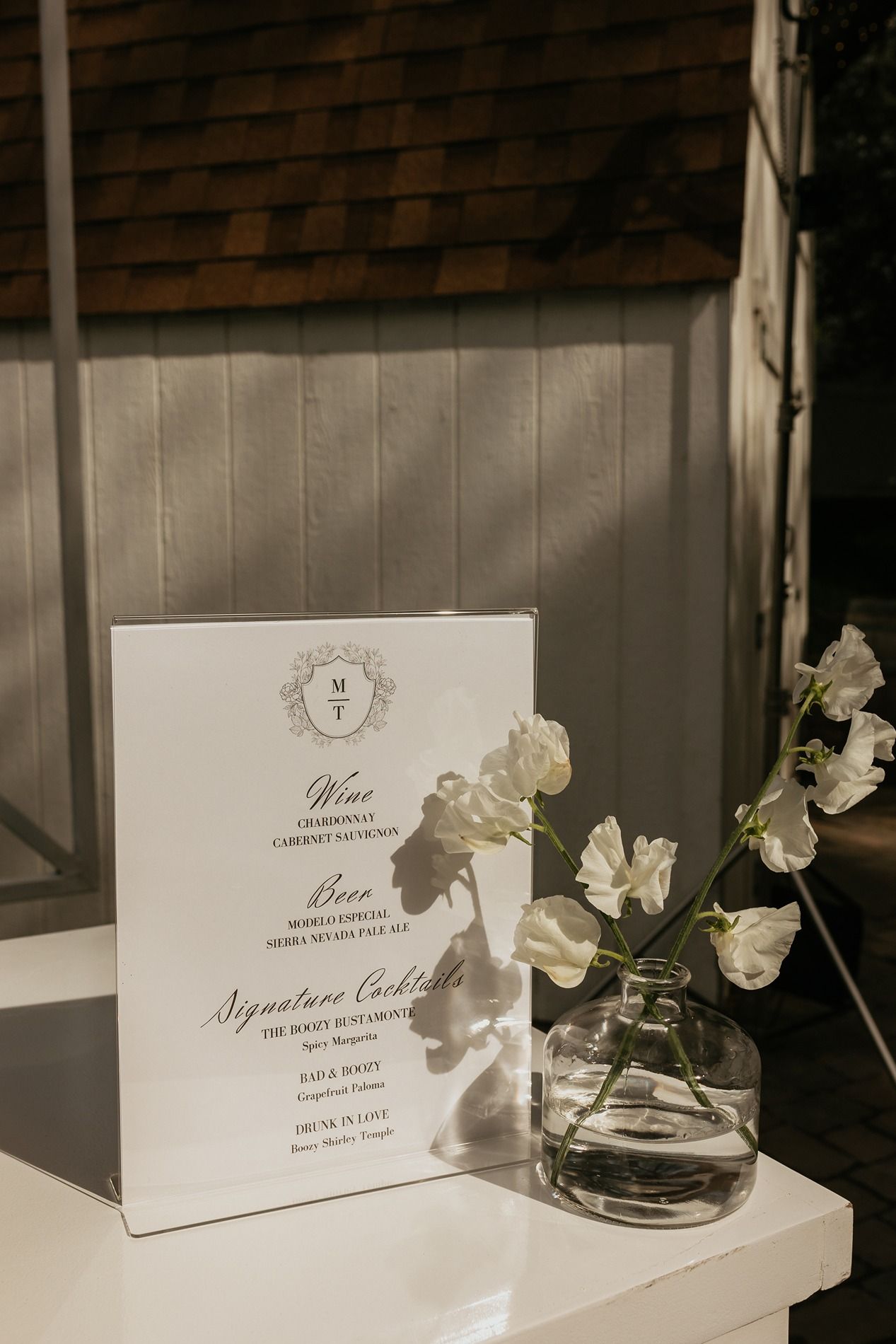 Elegant wedding stationery and white flowers displayed on a windowsill with natural lighting at The Oaks at Duncan Lane.