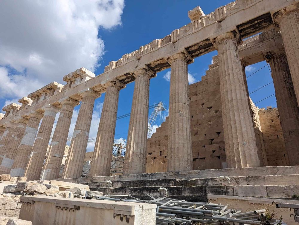 Ancient Greek Parthenon columns stand against blue sky at the Acropolis in Athens, Greece.