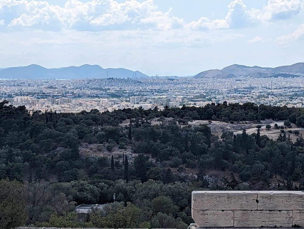 A panoramic view of mountains and urban development stretches across the horizon on a clear day.