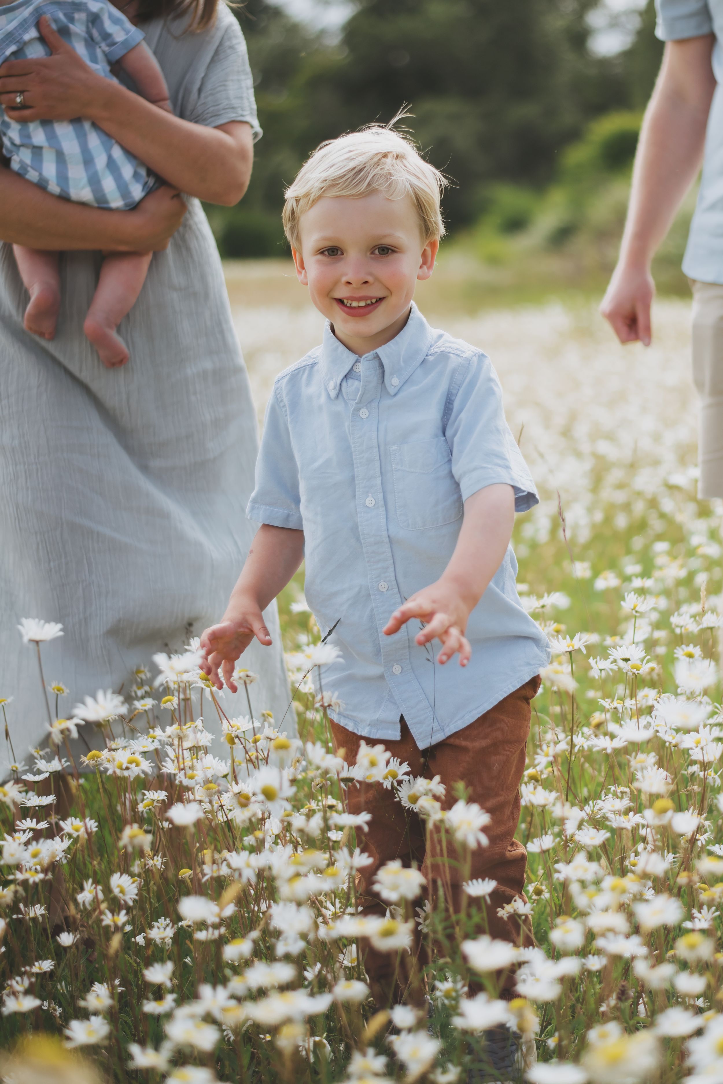 A child explores a field of blooming white daisies on a sunny summer day.