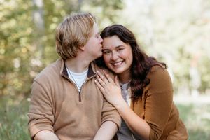 Candid engagement photos showing sweet moments between a couple in casual attire at Boyne Mountain Resort. Candid documentary photographer.