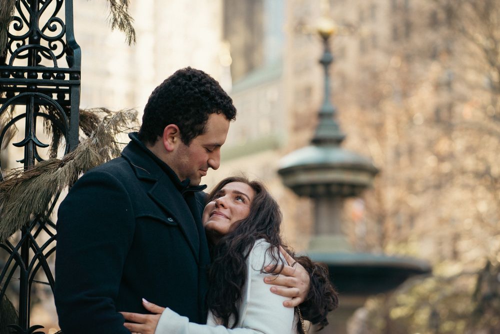 Romantic couple embraces and kisses in multiple black and white wedding photos against stone architecture backdrop.