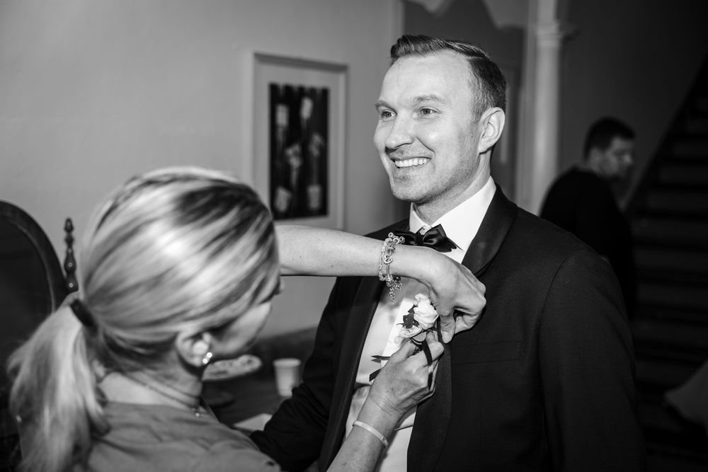 Black and white photo of wedding preparations in intimate setting.