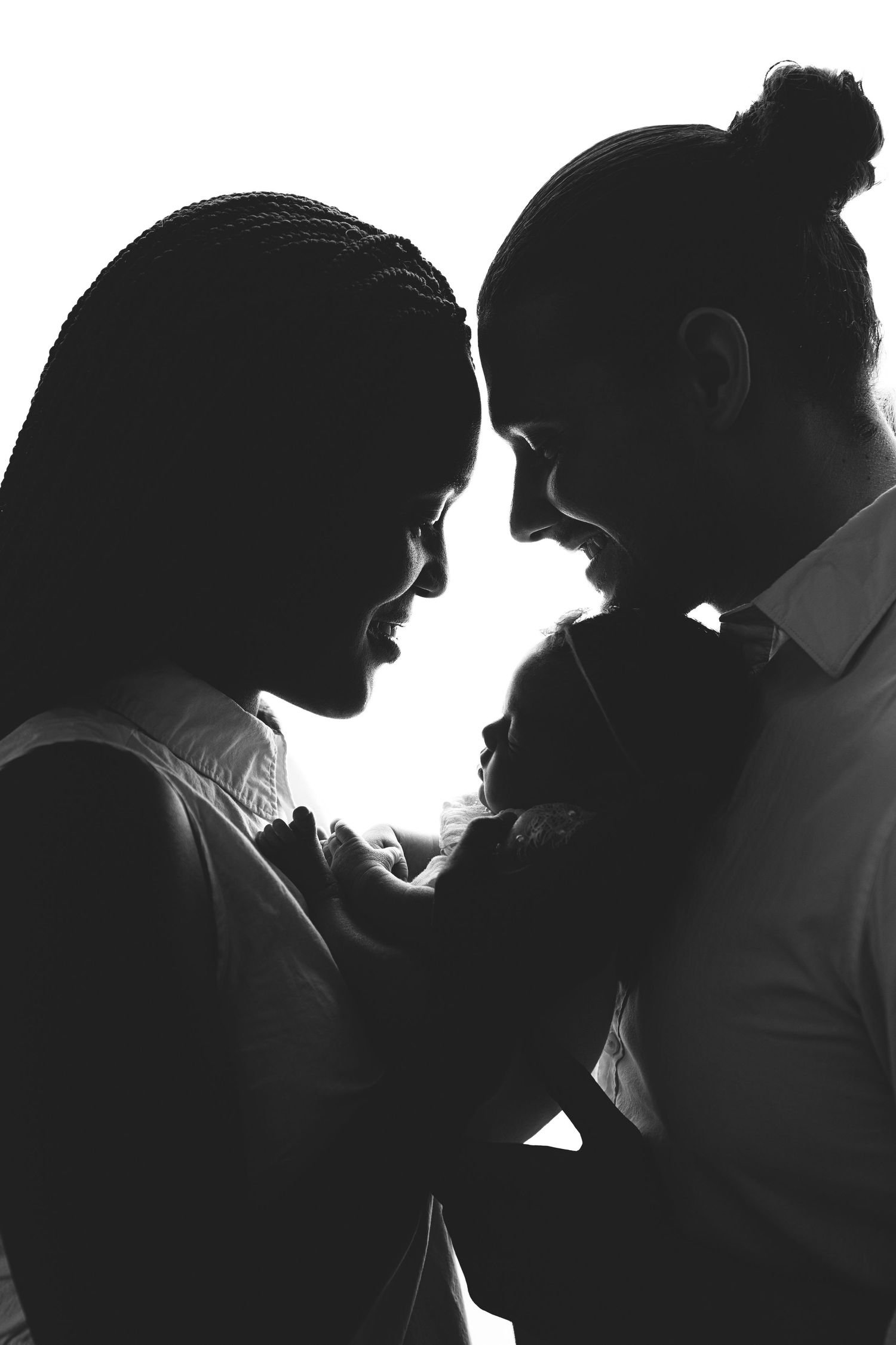 Artistic maternity portrait in sepia tones showing an expectant mother in a flowing white shirt against neutral background. Paloma Schell