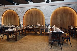 Modern restaurant interior with curved wooden walls and dark furniture creates a warm ambiance.