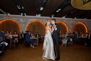 Wedding reception panorama showing couples dancing in an elegant ballroom with warm lighting.
