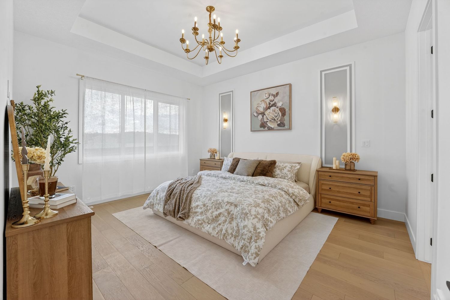 Spacious master bedroom with white walls, hardwood floors and modern ceiling fan.