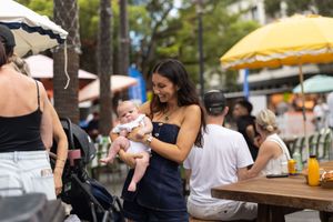 People enjoying drinks and food at an outdoor patio restaurant on a sunny day.