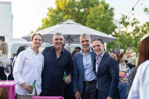 A group of people enjoying drinks and conversation at an outdoor social gathering or party.