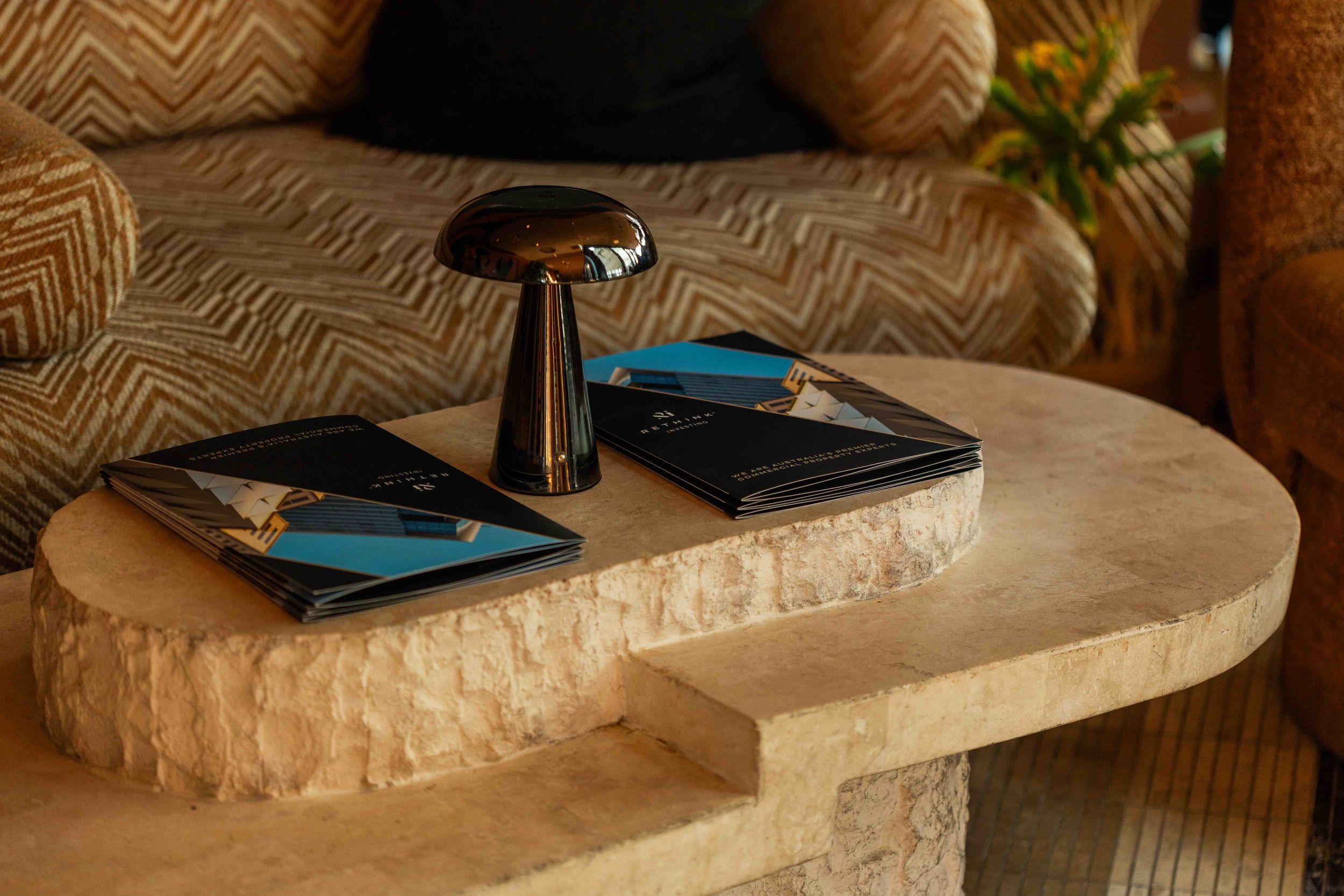 Close-up view of a curved stone bathroom vanity counter with dark fixtures and blue accents.