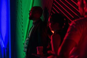 Colorful red, green and blue stage lighting creates dramatic shadows and silhouettes during a performance.