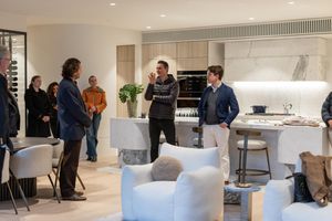 A modern office space with white countertops and people gathered in a bright, open layout interior.