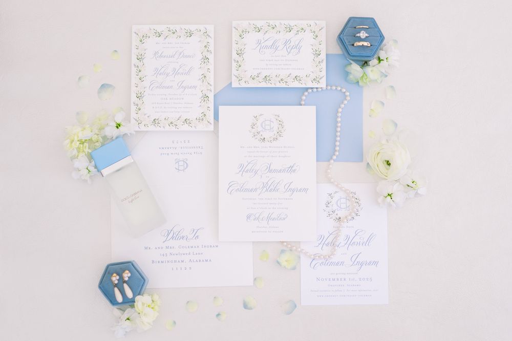 Elegant wedding invitation suite in white and powder blue with floral accents.