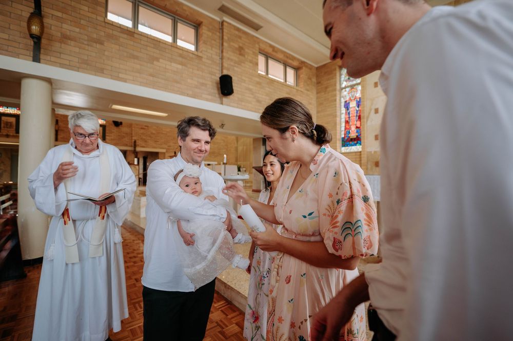 A group in white attire celebrates with champagne during a wedding reception in a rustic wooden venue.
