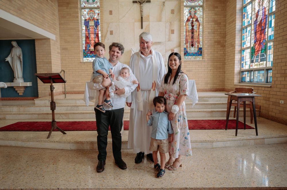 People enjoying a joyful moment together inside a church with stained glass windows and stone walls.