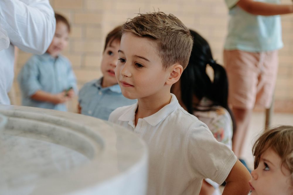 Children participate in a hands-on cooking class while learning culinary skills in a bright kitchen setting.