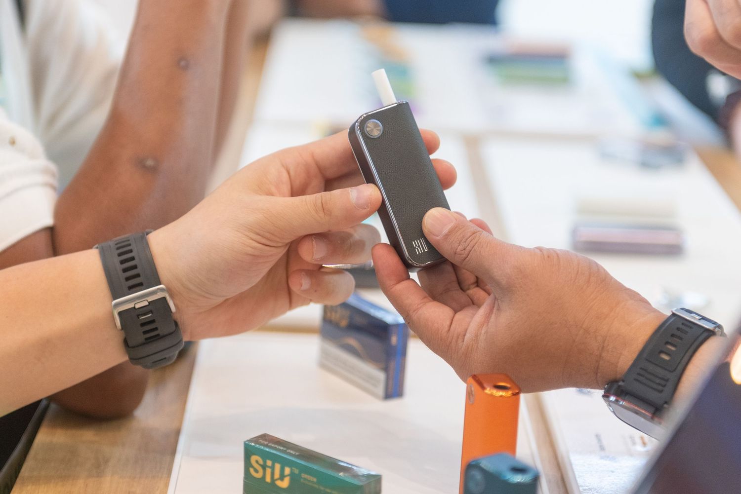 Close-up view of hands using various mobile devices and smartphones for digital communication and browsing.