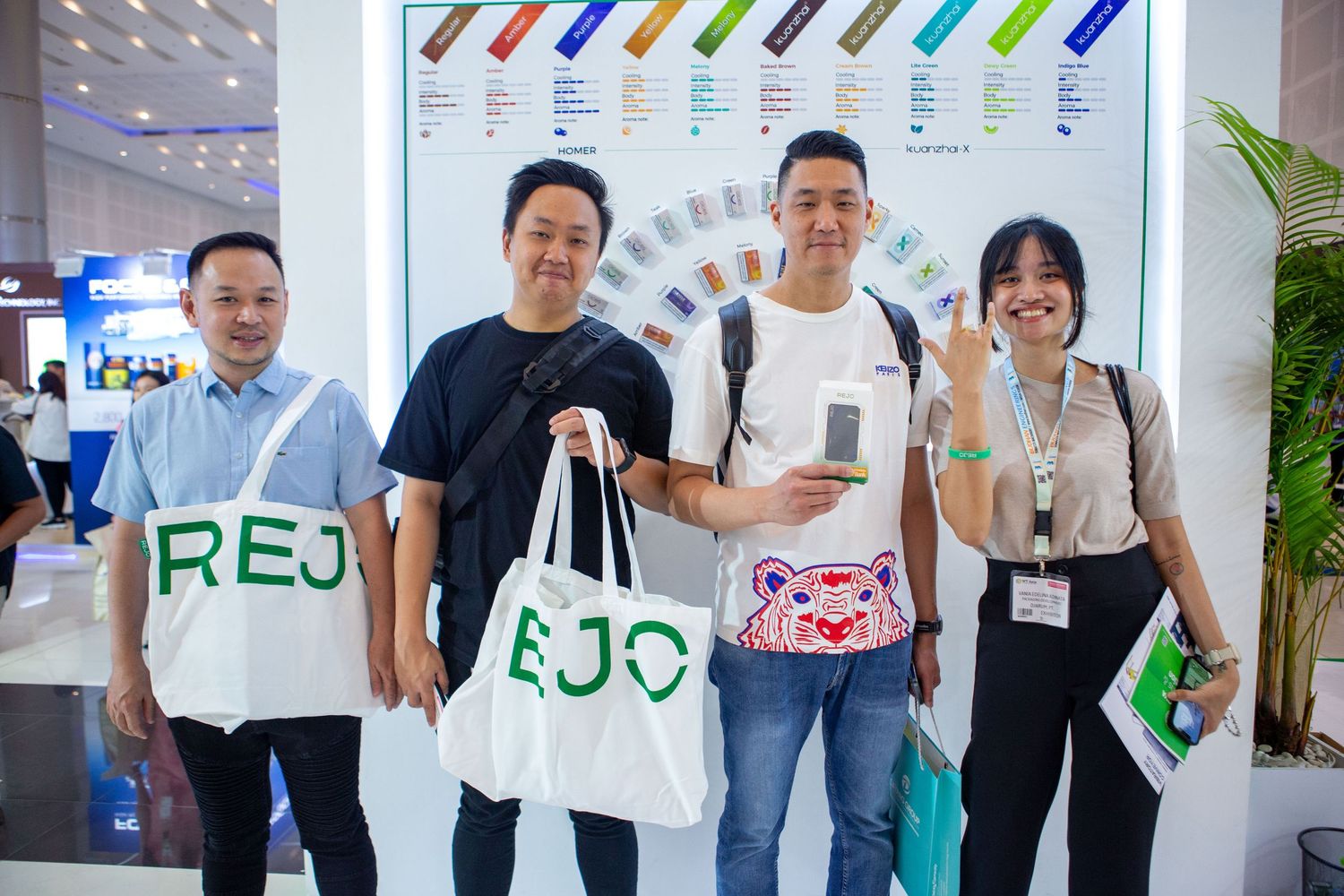 People in white shirts gather at a tech event, holding promotional materials and shopping bags.