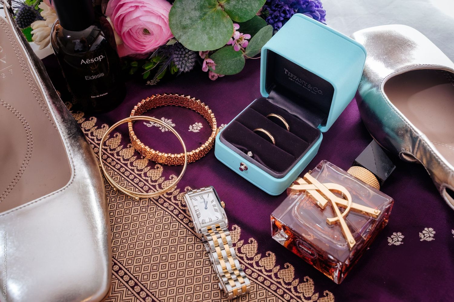Colorful jewelry and accessories including necklaces, rings, and earrings displayed on a purple surface.