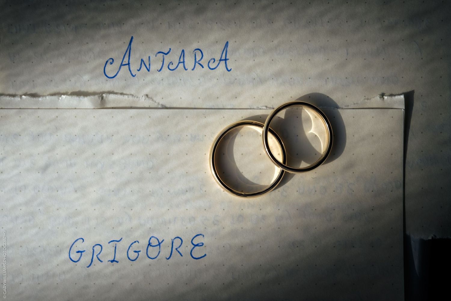 A collection of wedding rings displayed on a textured surface with handwritten text above.