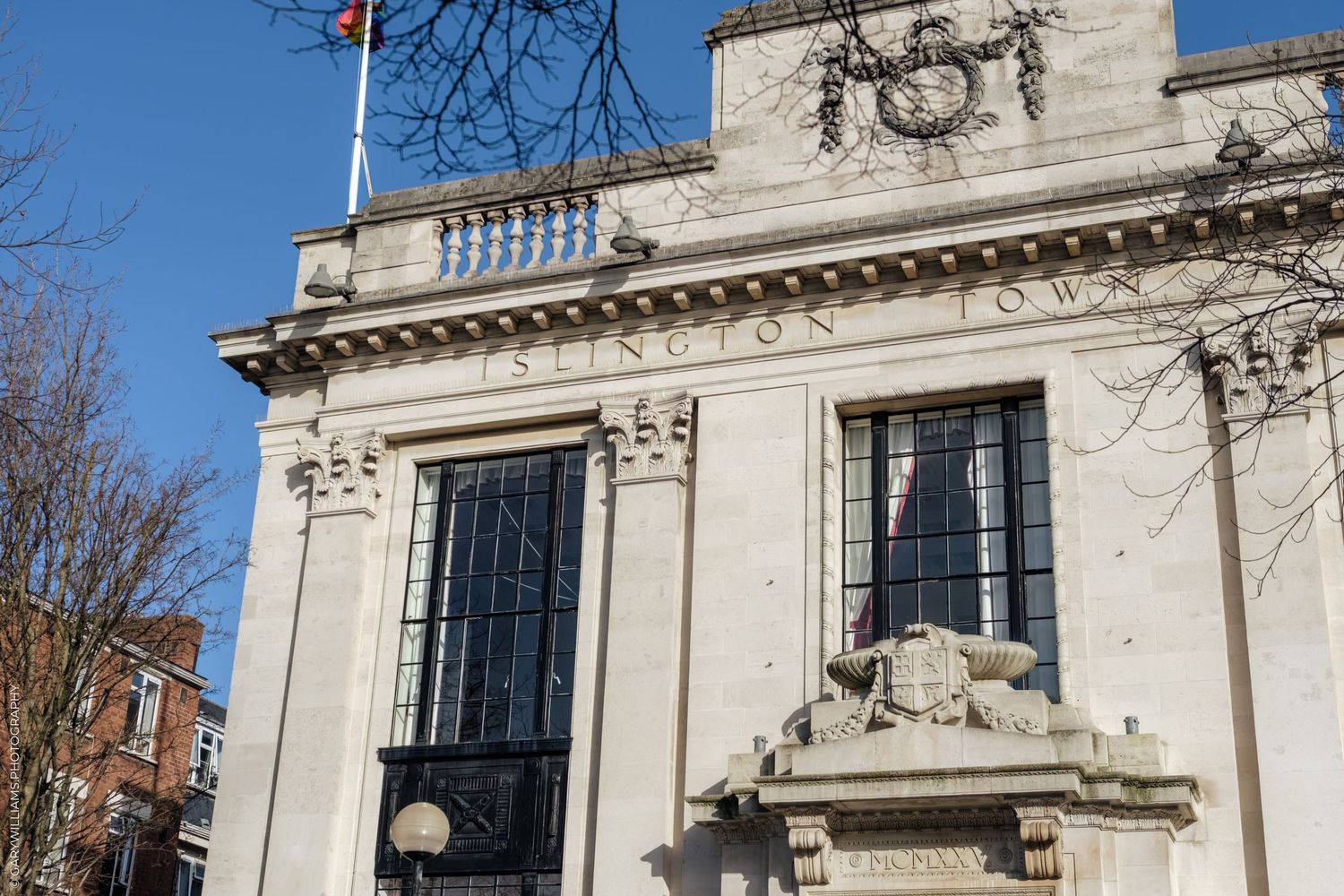 Ornate white stone building facade with classical architectural details and tall windows in a historic style.