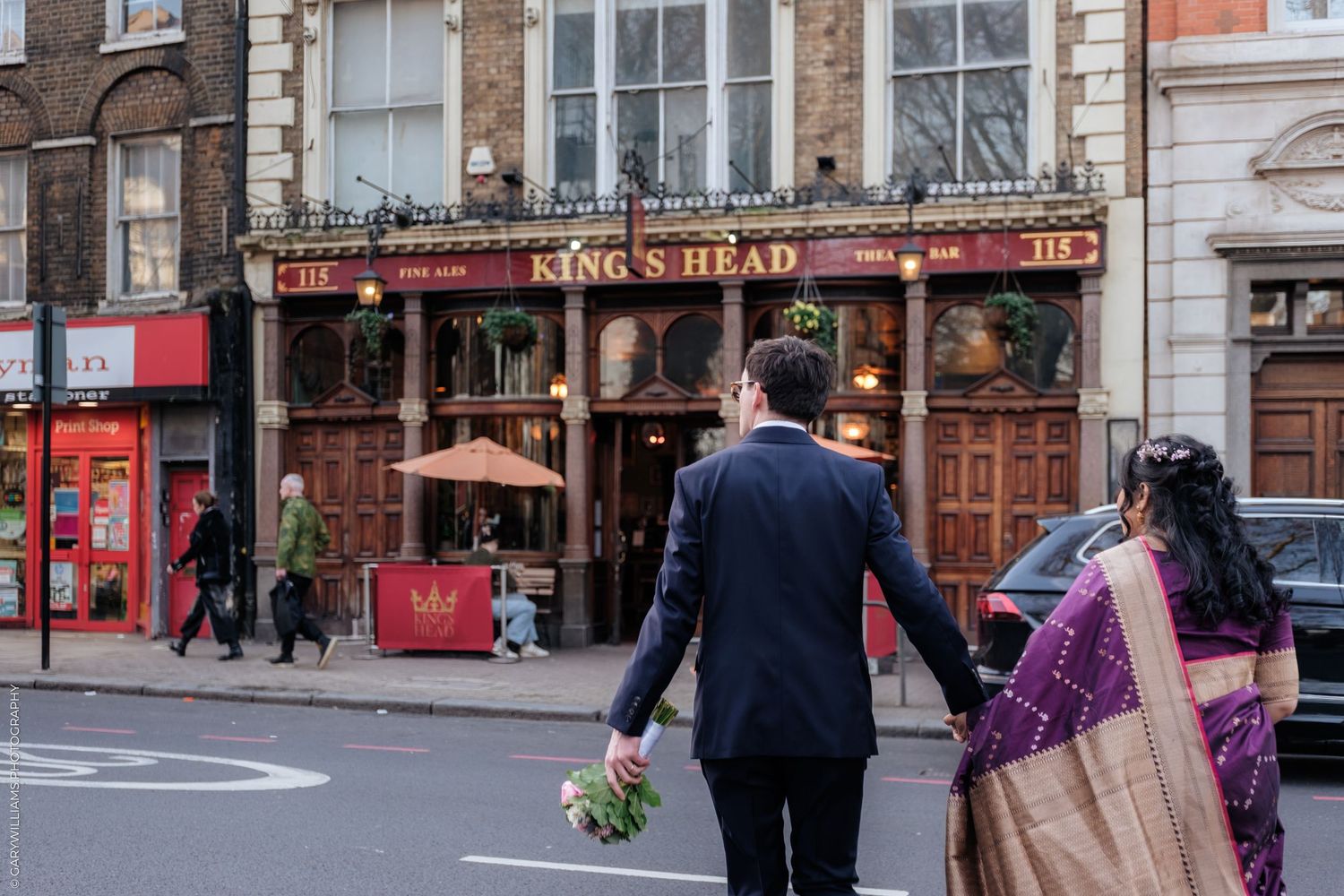 A historic street scene with red brick buildings and storefronts including the King's Head pub in Islington.