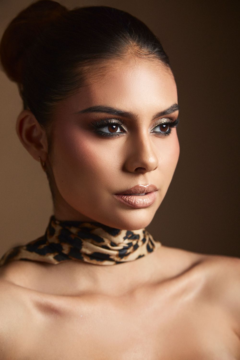 Close-up beauty portrait with leopard print choker and dramatic makeup.