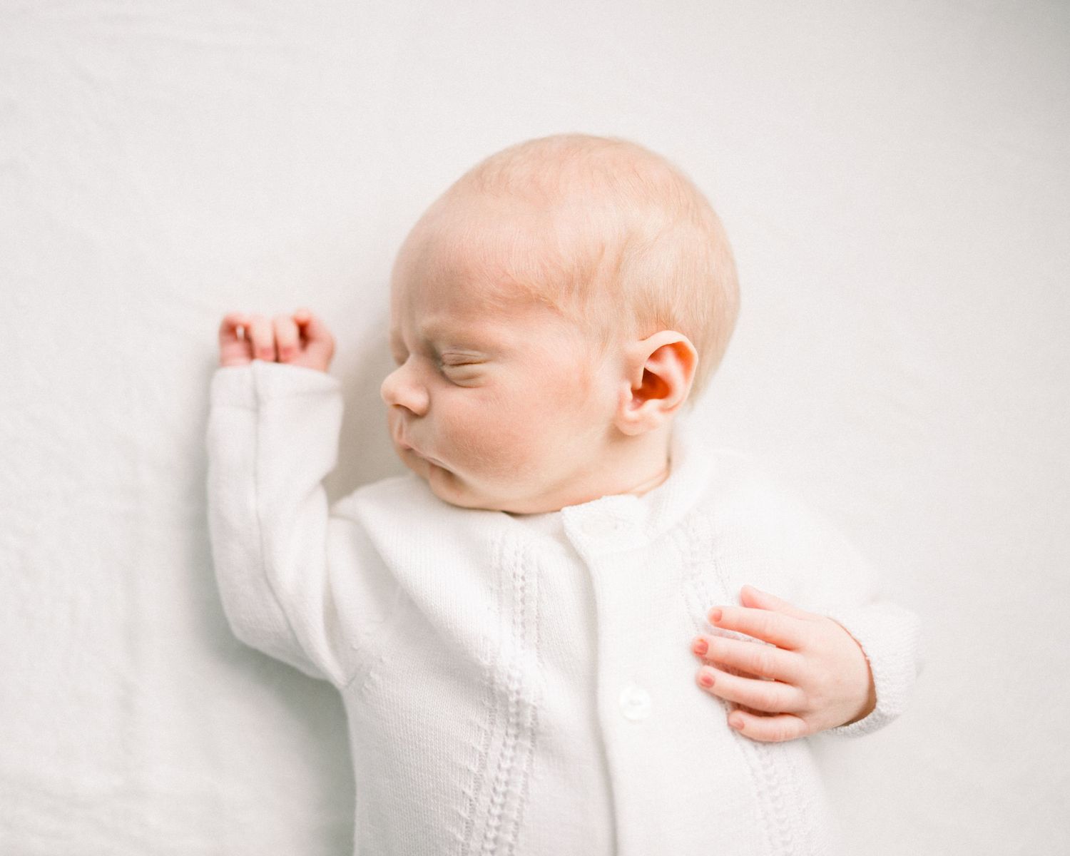 Newborn baby in white neutral outfit taken by a washington dc newborn photographer