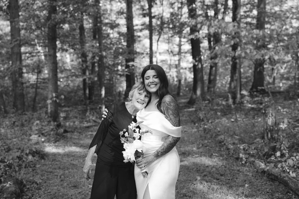 A couple shares a romantic moment together in a serene forest setting during their wedding photo session.