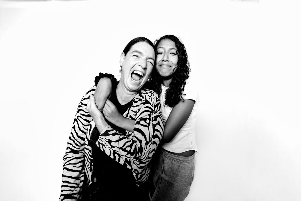 Three candid black and white photos showing friends laughing and embracing in casual moments.