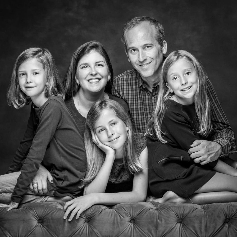 Black and white family portrait series showing candid moments and loving interactions while lounging together.
